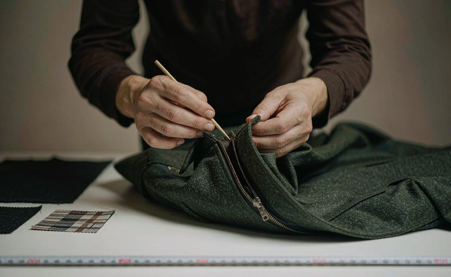 Inspector checking the seam of a wool jacket on an inspection table